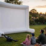 How to Set Up An Inflatable Projector Screen in 2026 Inflatable projector screen being set up on lawn