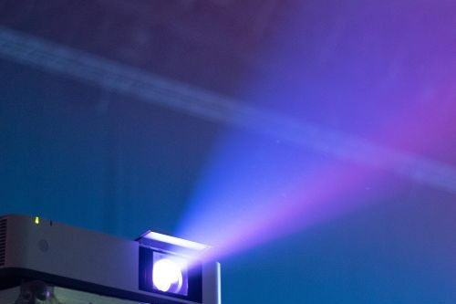Projector casting a bright beam in a dark room - How Many Lumens Do I Need For A Projector?